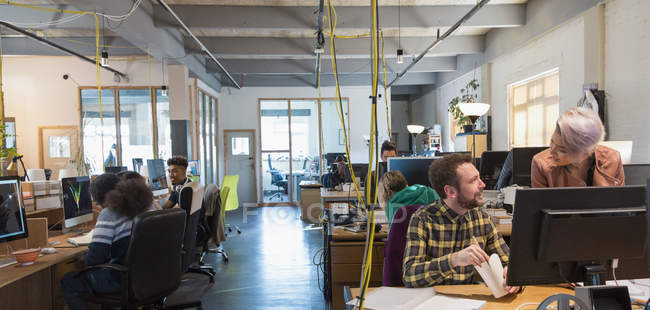Творческие бизнесмены, работающие в офисе открытого плана — стоковое фото