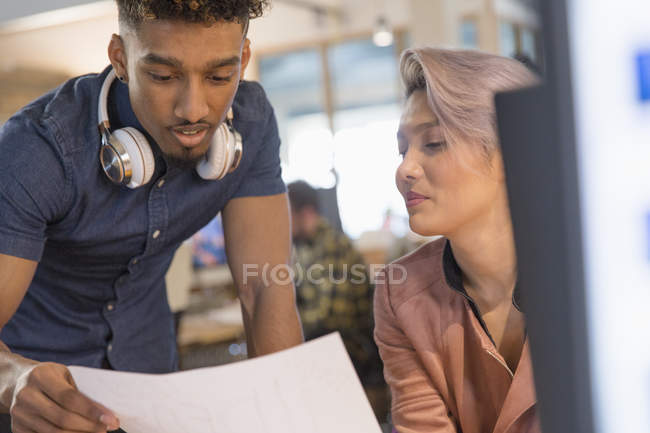 Creative business people discussing paperwork in office — Stock Photo
