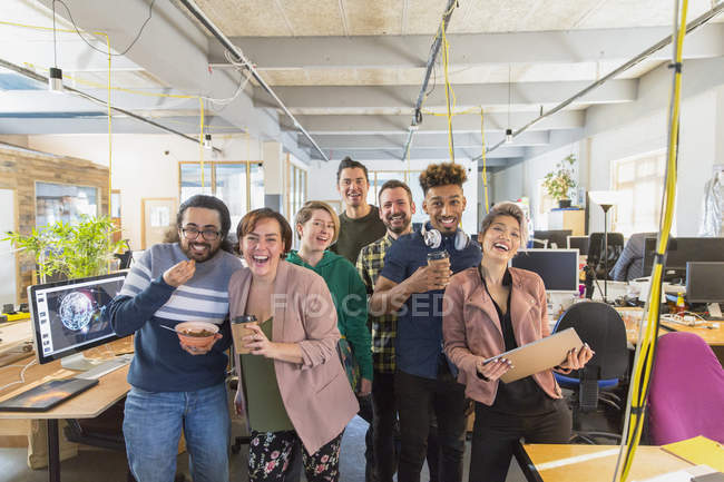 Retrato feliz, equipo creativo juguetón del negocio en oficina abierta - foto de stock
