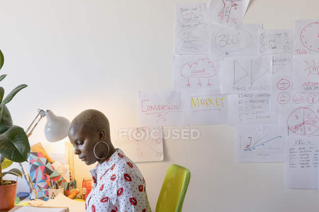 Empresaria creativa trabajando en el escritorio en la oficina - foto de stock