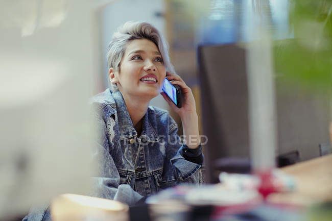 Творческая деловая женщина разговаривает по смартфону, размытый фон — стоковое фото