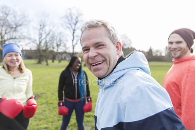Portrait smiling, confident man boxing with friends in park — Stock Photo