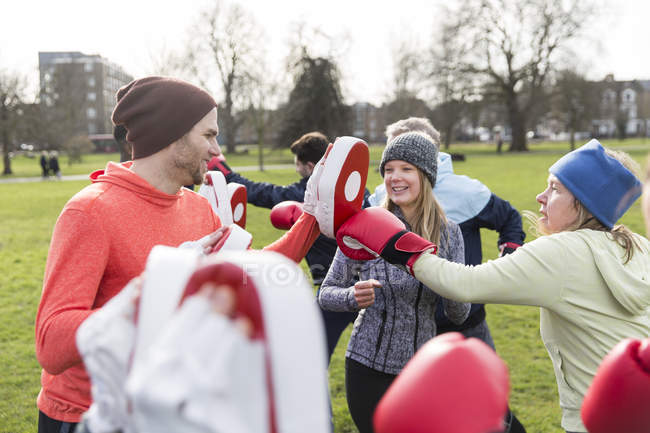 Glückliche Freunde boxen im grünen Park — Stockfoto