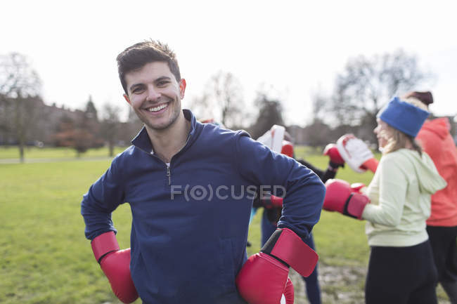 Porträt lächelt, selbstbewusster Mann boxt im Park — Stockfoto