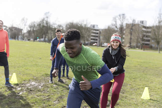 Man and woman exercising, doing team building exercise in park — Stock Photo
