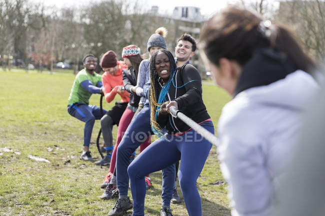 Équipe déterminée à tirer la corde dans un remorqueur de guerre dans un parc — Photo de stock