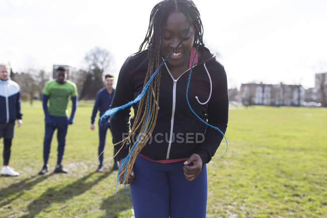 Mulher sorridente exercitando-se no parque verde — Fotografia de Stock
