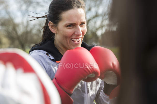 Mujer decidida boxeando en el parque verde - foto de stock