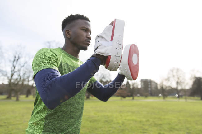 Focused man boxing in green park — Stock Photo
