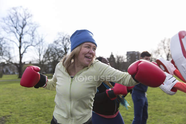 Вирішена старша жінка бокс в зеленому парку — стокове фото