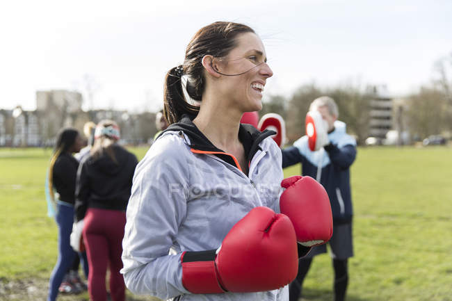 Sorridente, donna sicura di sé boxe nel parco — Foto stock