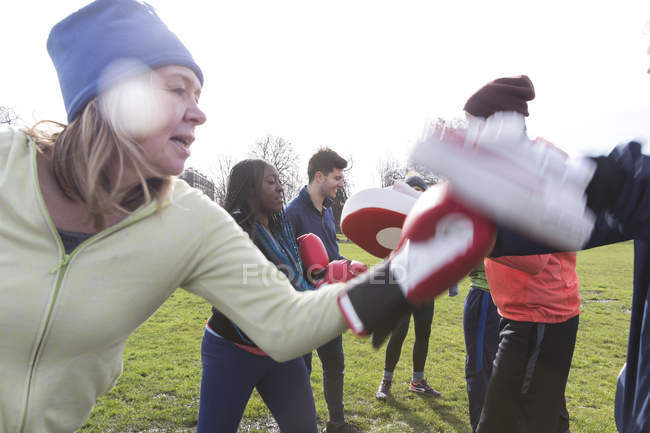 Determined senior woman boxing in green park — Stock Photo