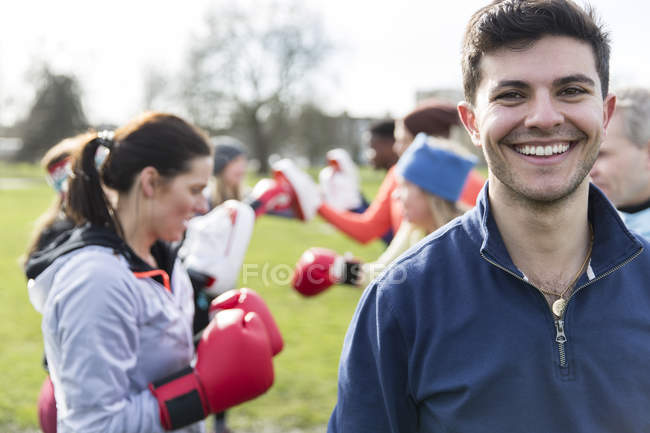 Retrato sonriente, joven confiado boxeando en el parque - foto de stock