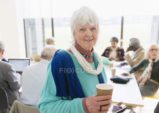 Portrait confident senior businesswoman drinking coffee in meeting — Stock Photo