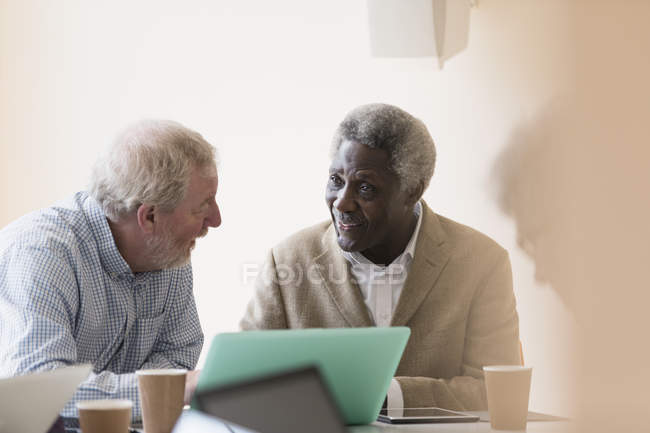 Empresários seniores usando laptop em reunião — Fotografia de Stock