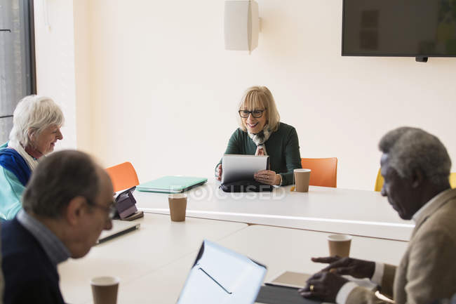 Femme d'affaires senior utilisant une tablette numérique, réunion principale de la salle de conférence — Photo de stock