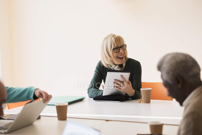 Lächelnde, selbstbewusste Seniorin mit digitalem Tablet leitet Konferenzraum-Treffen — Stockfoto