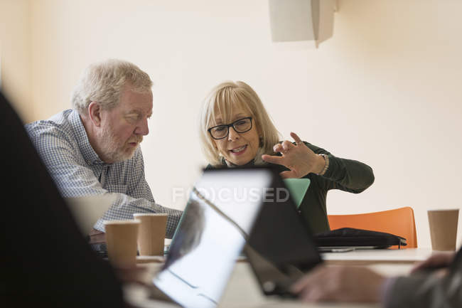 Senior uomini d'affari che utilizzano il computer portatile in sala conferenze riunione — Foto stock