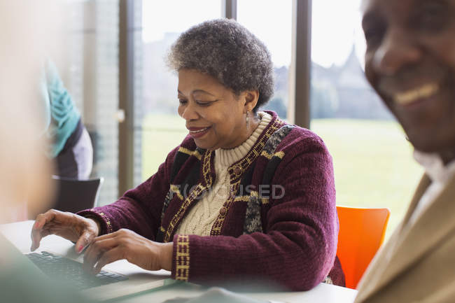 Smiling, confident senior businesswoman using laptop — Stock Photo