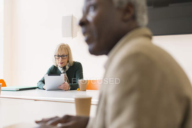 Femme d'affaires senior utilisant une tablette numérique dans une réunion de salle de conférence — Photo de stock