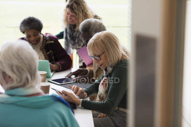 Pessoas de negócios sênior trabalhando, usando tablets digitais em reunião de sala de conferências — Fotografia de Stock