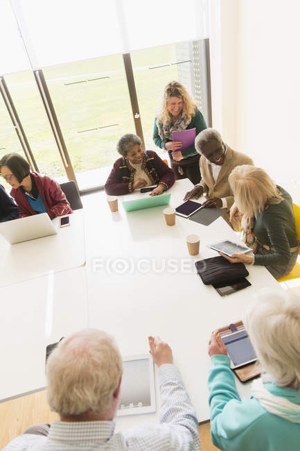 Старшие бизнесмены используют цифровые планшеты и ноутбуки в конференц-зале — стоковое фото