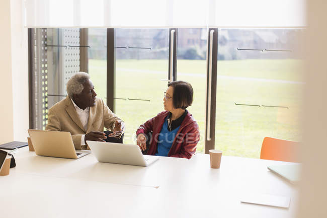 Gli uomini d'affari anziani che parlano in sala conferenze — Foto stock