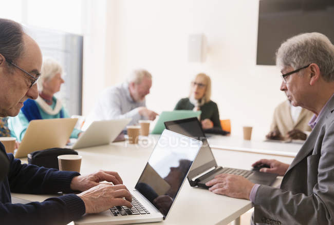 Senior-Geschäftsleute nutzen Laptops im Konferenzraum — Stockfoto