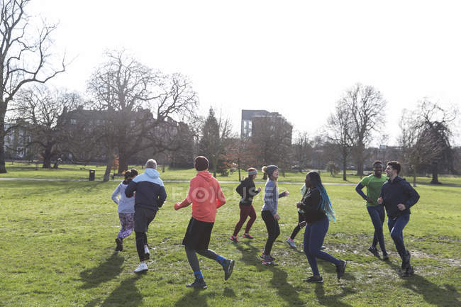 Coureurs jogging en cercle dans un parc ensoleillé — Photo de stock
