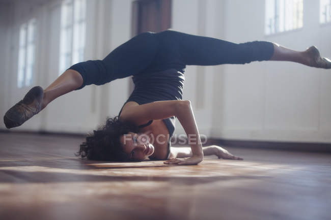 Strong young female dancer practicing in dance studio — Stock Photo