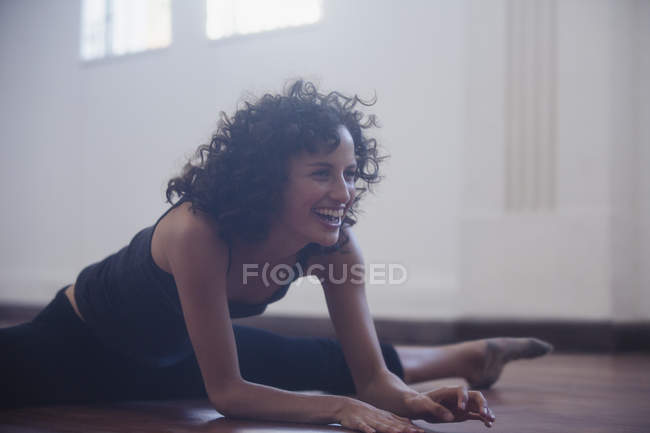Feliz, confiante jovem dançarina alongamento no estúdio de dança — Fotografia de Stock