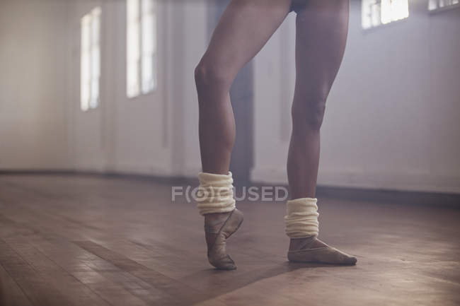 Jovem dançarina de balé do sexo feminino alongamento pé no estúdio de dança — Fotografia de Stock
