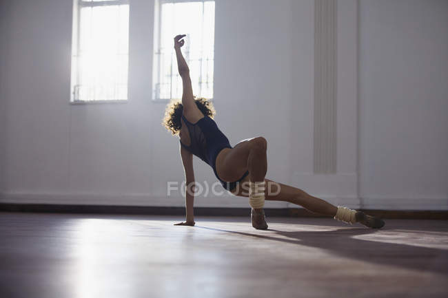 Graceful young female dancer practicing in dance studio — Stock Photo