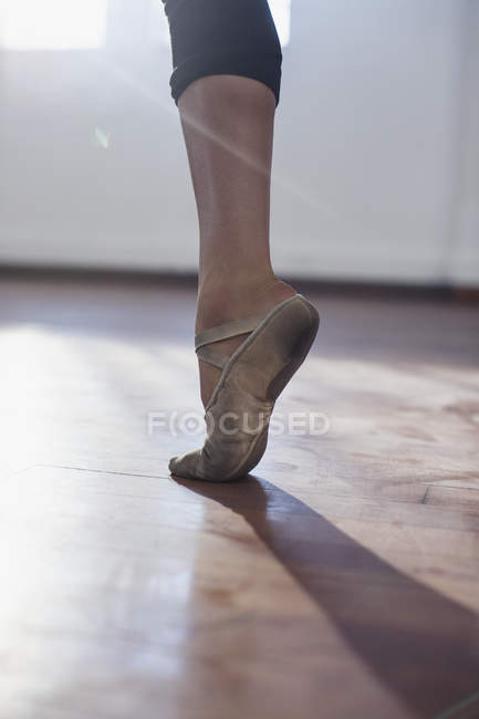 Primer plano joven bailarina de ballet practicando en zapato de ballet - foto de stock