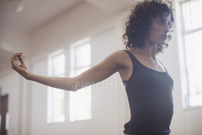 Fokussierte, zielstrebige junge Tänzerin dehnt sich im Tanzstudio — Stockfoto