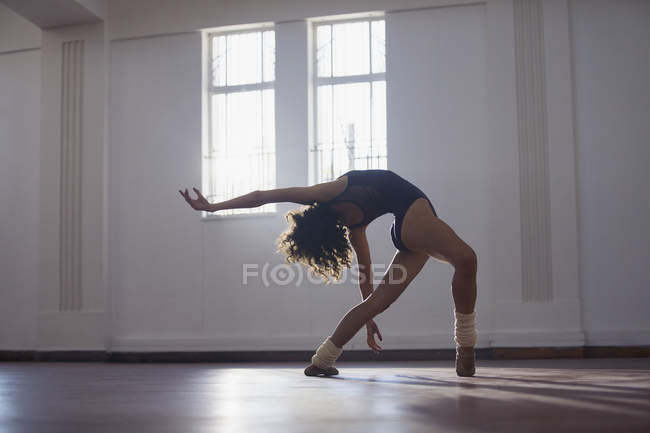 Изящная, гибкая молодая танцовщица, практикующая в танцевальной студии — стоковое фото