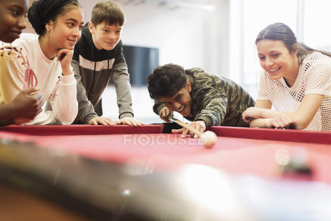 Teenagers playing pool indoors — Stock Photo