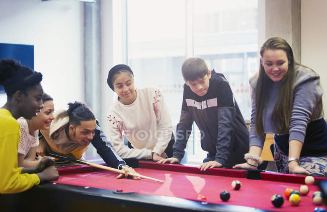 Teenagers playing pool at school — Stock Photo