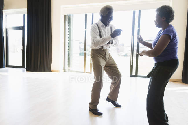 Brincalhão casal sênior ativo dançando no estúdio de dança — Fotografia de Stock
