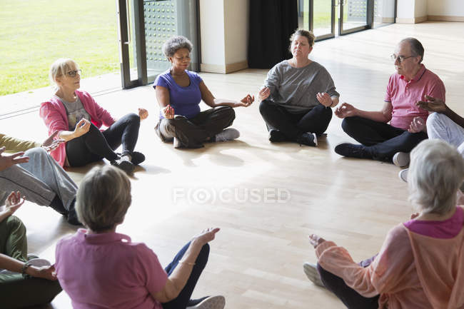 Serene active seniors meditating in circle — Stock Photo