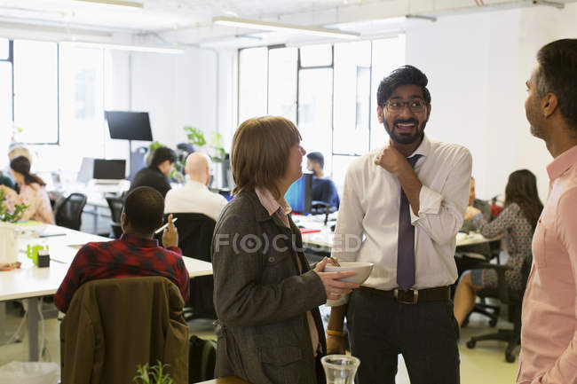 Business people talking and eating in office — Stock Photo