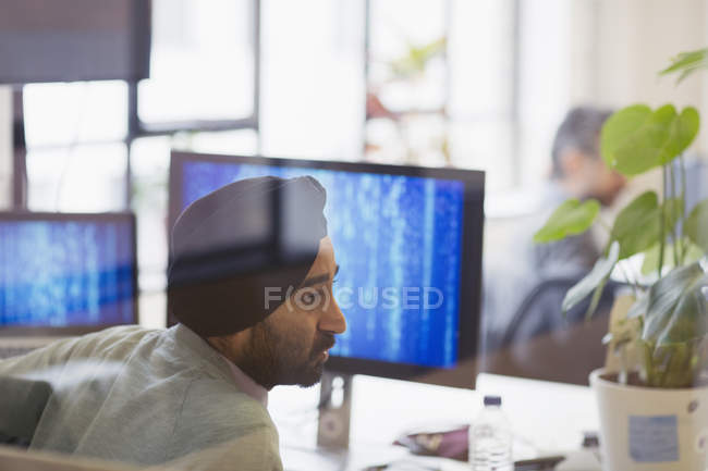 Индийский программист в тюрбане работает в офисе — стоковое фото