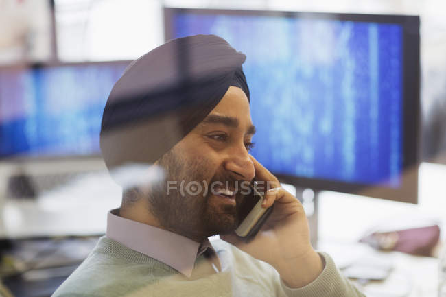 Programador de computador indiano em turbante falando no telefone inteligente no escritório — Fotografia de Stock