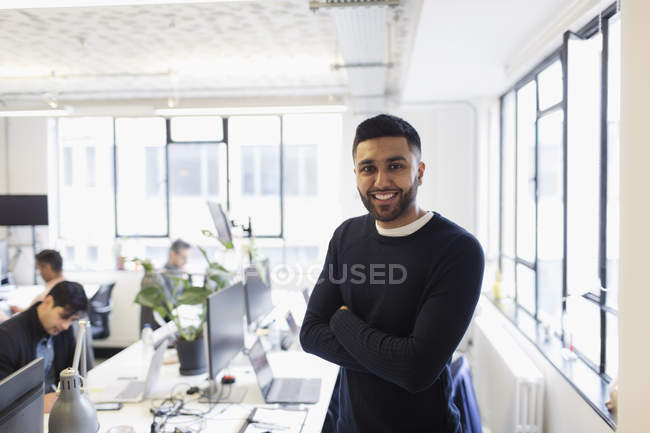 Porträt lächelnder, selbstbewusster Geschäftsmann im Großraumbüro — Stockfoto