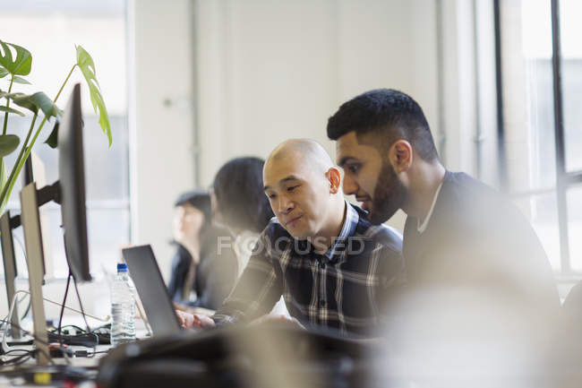 Бизнесмен, работающий за ноутбуком в офисе — стоковое фото