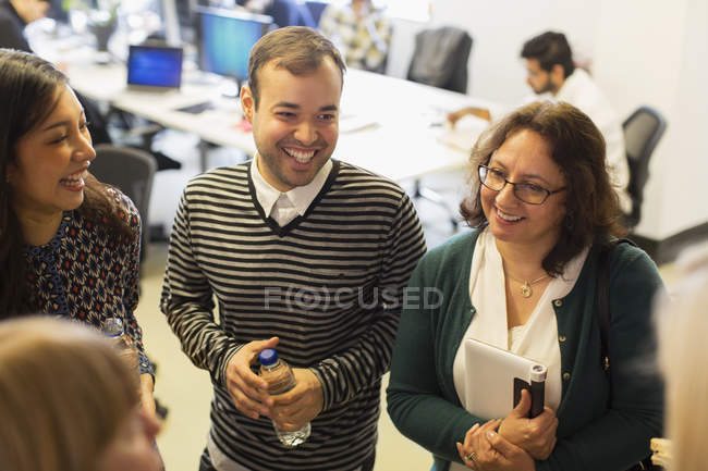 Sorridenti uomini d'affari che parlano in ufficio — Foto stock