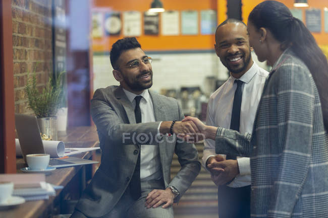 Business people handshaking in cafe — Stock Photo