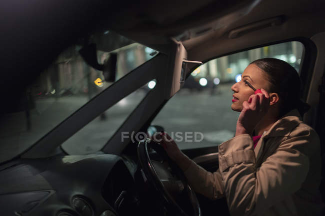 Businesswoman applying mascara in car at night — Stock Photo