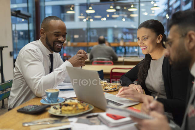 Ділові люди зустрічаються, працюють на ноутбуці в кафе — стокове фото