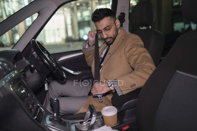 Homme d'affaires boucle la ceinture de sécurité dans la voiture — Photo de stock